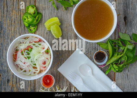 Pho Fast Food To Go on Wood Background with Peppers and Basil Stock Photo