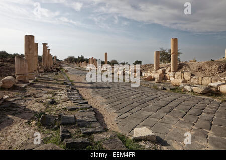 Paved axis road, Decomanus, pillars, ancient town of Gadara, Umm Qais, Jordan Stock Photo