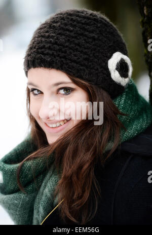 Smiling young woman wearing hat and scarf in winter, portrait Stock Photo