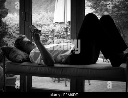 Teenage boy relaxing using smart phone Stock Photo