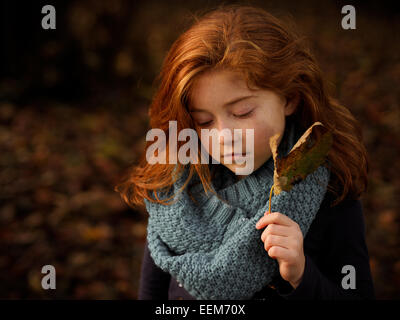 Red haired girl holding autumn leaf Stock Photo