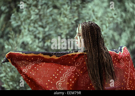 Rear view of a woman with braids dancing with a scarf Stock Photo