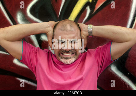Man frowning and holding head in hands Stock Photo
