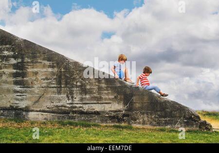 Two boys sitting on a wall Stock Photo