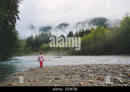 Boy standing at the edge of a lake, USA Stock Photo