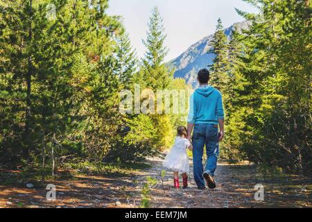 Father and daughter walking in forest, USA Stock Photo