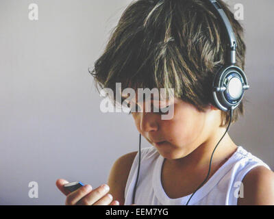 Boy wearing headphones listening to music Stock Photo