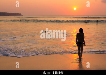 Indonesia, Bali, Woman watching sunset on beach Stock Photo