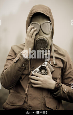 Man with analog camera wearing gas mask Stock Photo