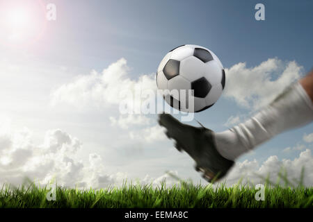 Blurred view of foot kicking soccer ball Stock Photo