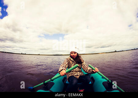 Caucasian girl rowing canoe on lake Stock Photo