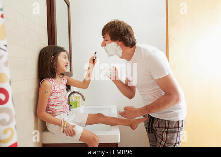 Father and daughter playing in bathroom Stock Photo