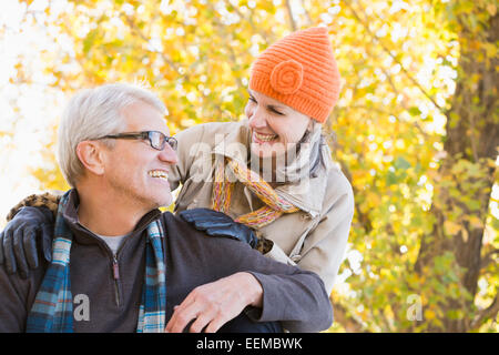 Older Caucasian couple smiling under autumn trees Stock Photo