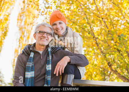 Older Caucasian couple smiling under autumn trees Stock Photo
