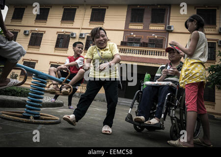 A group of children affected by Agent Orange dioxin playing in the small playground of the host institution Stock Photo