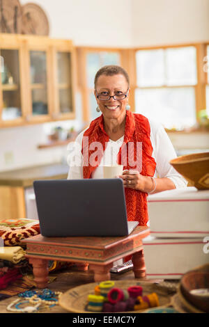 Older mixed race woman using laptop in home office Stock Photo