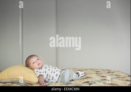 Newborn mixed race baby laying on bed Stock Photo