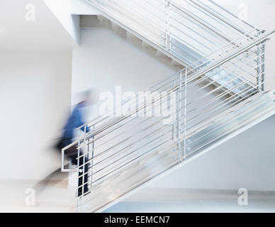 Blurred view of Black businessman climbing office staircase