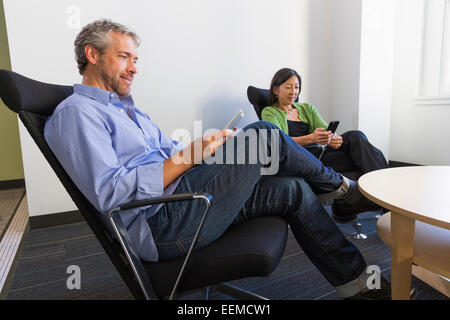 Business people using cell phones in office Stock Photo