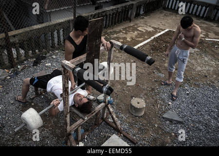 Several young people do dumbbell exercises at an improvised gym near the town square. Stock Photo