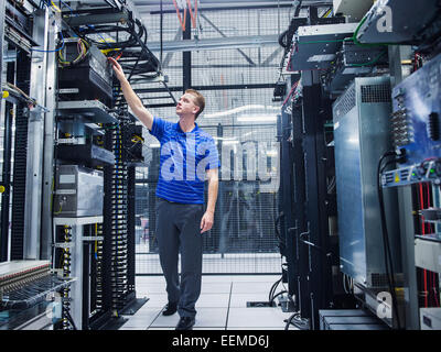 Caucasian technician working in server room Stock Photo
