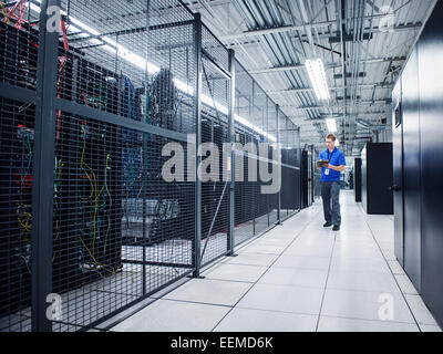 Caucasian technician using digital tablet in server room Stock Photo