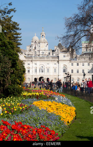 St James's Park flower beds with tulips in spring looking towards Horseguards Parade with people walking by Westminst Stock Photo