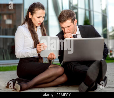 Young Business couple sitting near th office focus on shoes Stock Photo