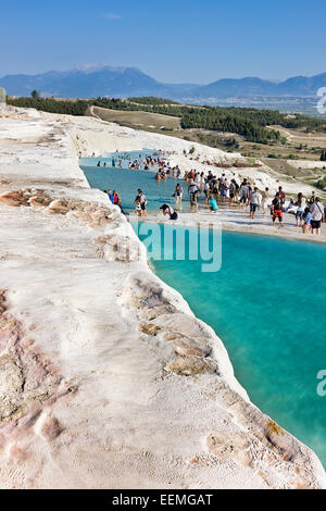 Crowd of tourists walking on travertine terraces. Pamukkale, Denizli Province, Turkey. Stock Photo