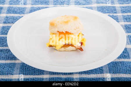 A delicious, hot biscuit with scrambled eggs, bacon and melted cheddar cheese Stock Photo