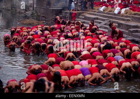 Kathmandu, Nepal. 20th Jan, 2015. Nepalese Hindu women devotees take a holy dip in the Bagmati River during the Madhav Narayan festival at Pashupatinath in Kathmandu, Nepal, Jan. 20, 2015. Nepalese Hindu women observe a fast and pray to Goddess Swasthani for longevity of their husbands and family prosperity during the month-long festival. © Pratap Thapa/Xinhua/Alamy Live News Stock Photo