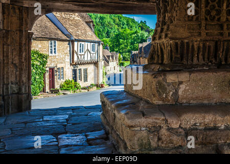 View through the medieval market cross in the Cotswold village of Castle Combe in Wiltshire. Stock Photo