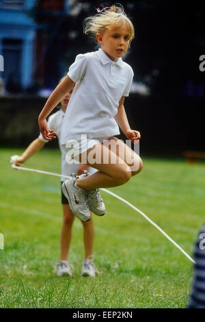 A young girl rope skipping at a school sports day. England. UK Stock Photo