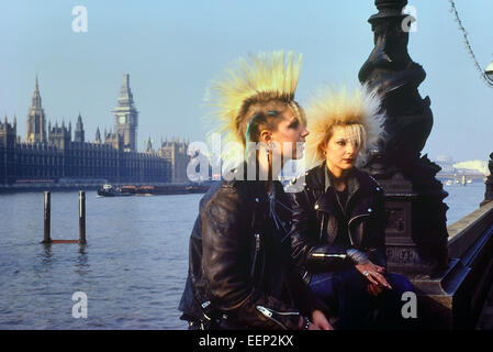 Two teenage punk rocker girls (Jackie & Renata) sitting on the Embankment opposite The Houses of Parliament. London. 1980's Stock Photo