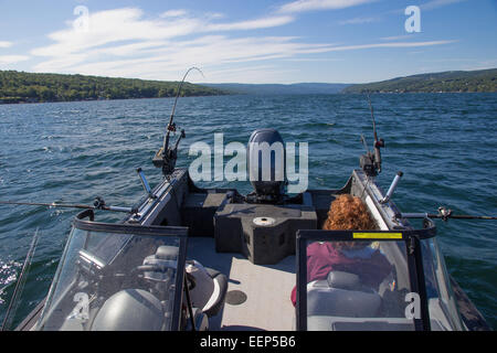 A lone angler sits in a boat while trolling for trout on the Finger Lakes in New York state. Stock Photo