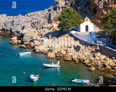 Tiny church and boats at St Pauls Bay Lindos Rhodes Greece Europe Stock Photo