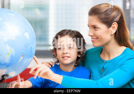 Happy school concept. Female teacher explaining geography to kid Stock Photo