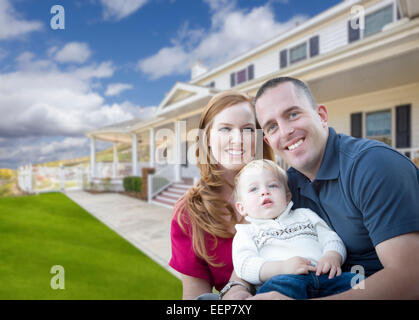 Happy Young Military Family in Front of Their Beautiful House. Stock Photo