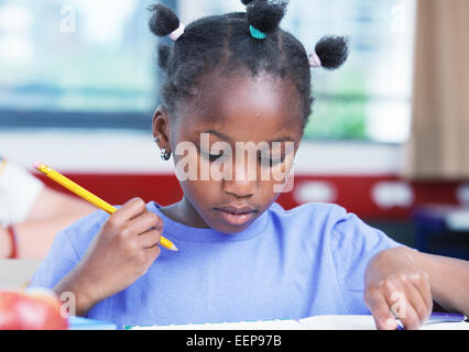 Afro american female student doing school work in classroom. Stock Photo