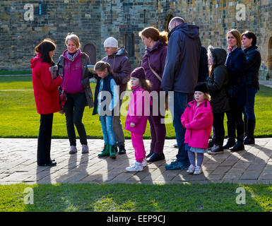 Guide taking a group of tourists on a tour of Alnwick Castle the location some of the Harry Potter films in Northumberland UK Stock Photo