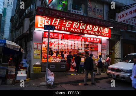 Illuminated supermarket shop front at night in Hong Kong, China Stock Photo