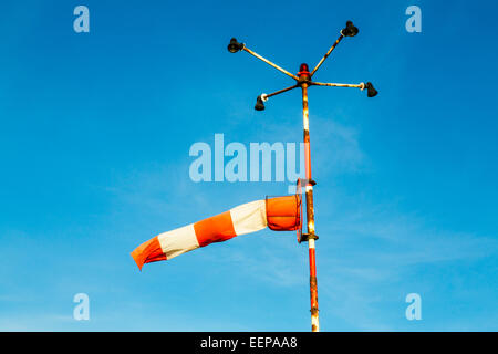 Windsock, on a rusty pole, for the determination of wind direction and wind speed at a helipad Stock Photo