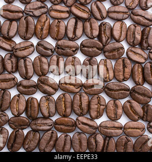 roasted coffee beans arranged into a regular pattern on white background Stock Photo