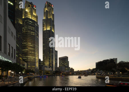 Shops and restaurants along the Central Promenade at Clarke Quay, Singapore River Walk at night. Tour boats on the river. Stock Photo