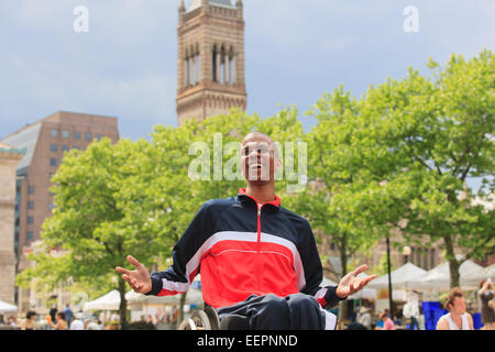 Man in wheelchair with Spinal Meningitis at a city Farmer's Market Stock Photo