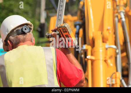 Construction supervisor with electronic surveying rod Stock Photo