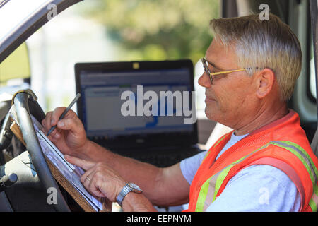 Construction supervisor logging work from truck Stock Photo