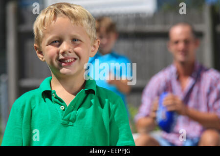 Happy boy with father and brother with hearing impairments playing in backyard Stock Photo