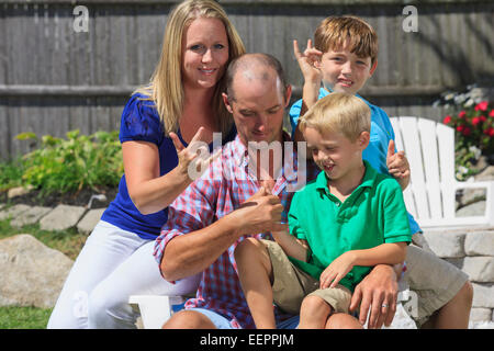 Portrait of a happy family with hearing impairments signing in American sign language Stock Photo