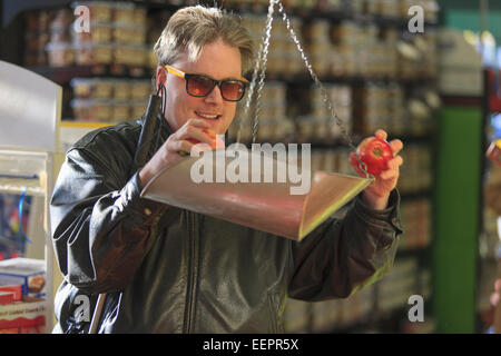 Man with congenital blindness measuring fruit at the grocery store Stock Photo